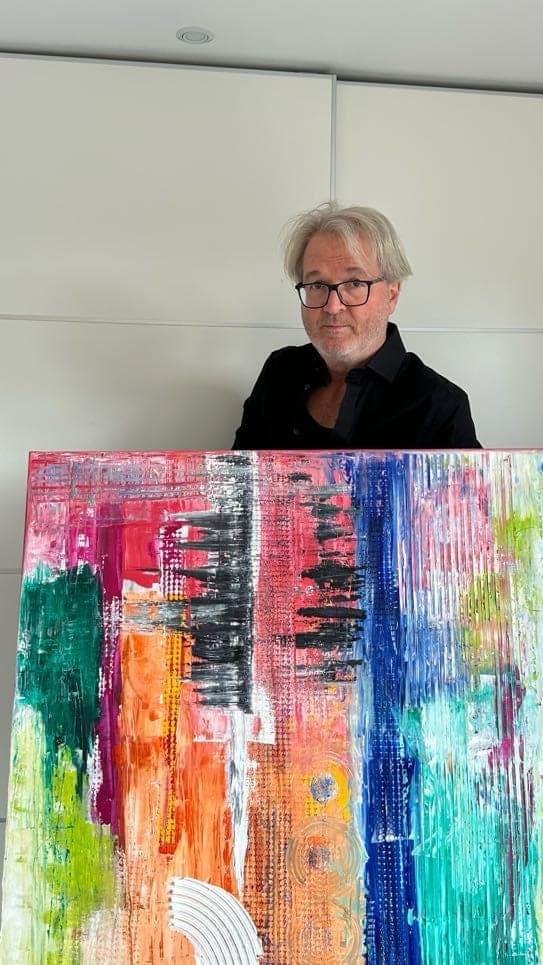 Mitsch Schulz trägt ein großes, farbiges Bild durchs Treppenhaus, Bild 6 von 6